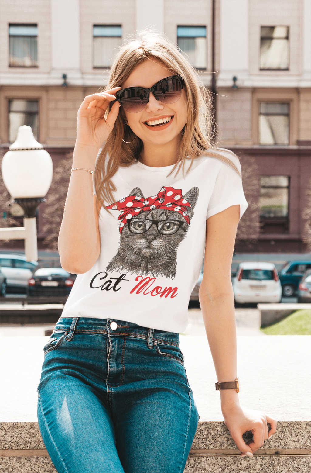 Woman wearing a t-shirt with a cat graphic and 'Cat Mom' text, standing outdoors.