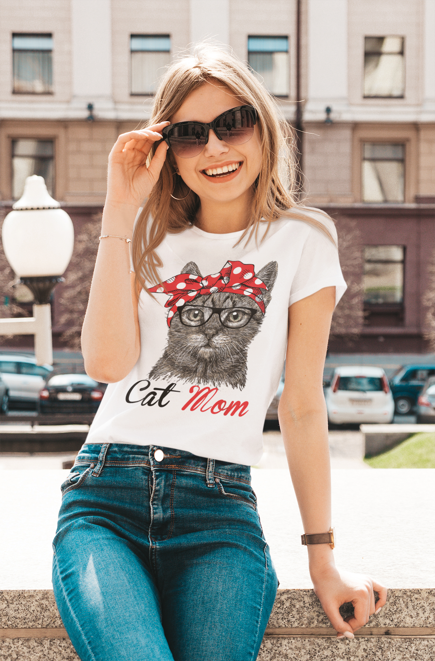 Woman wearing a t-shirt with a cat graphic and 'Cat Mom' text, standing outdoors.