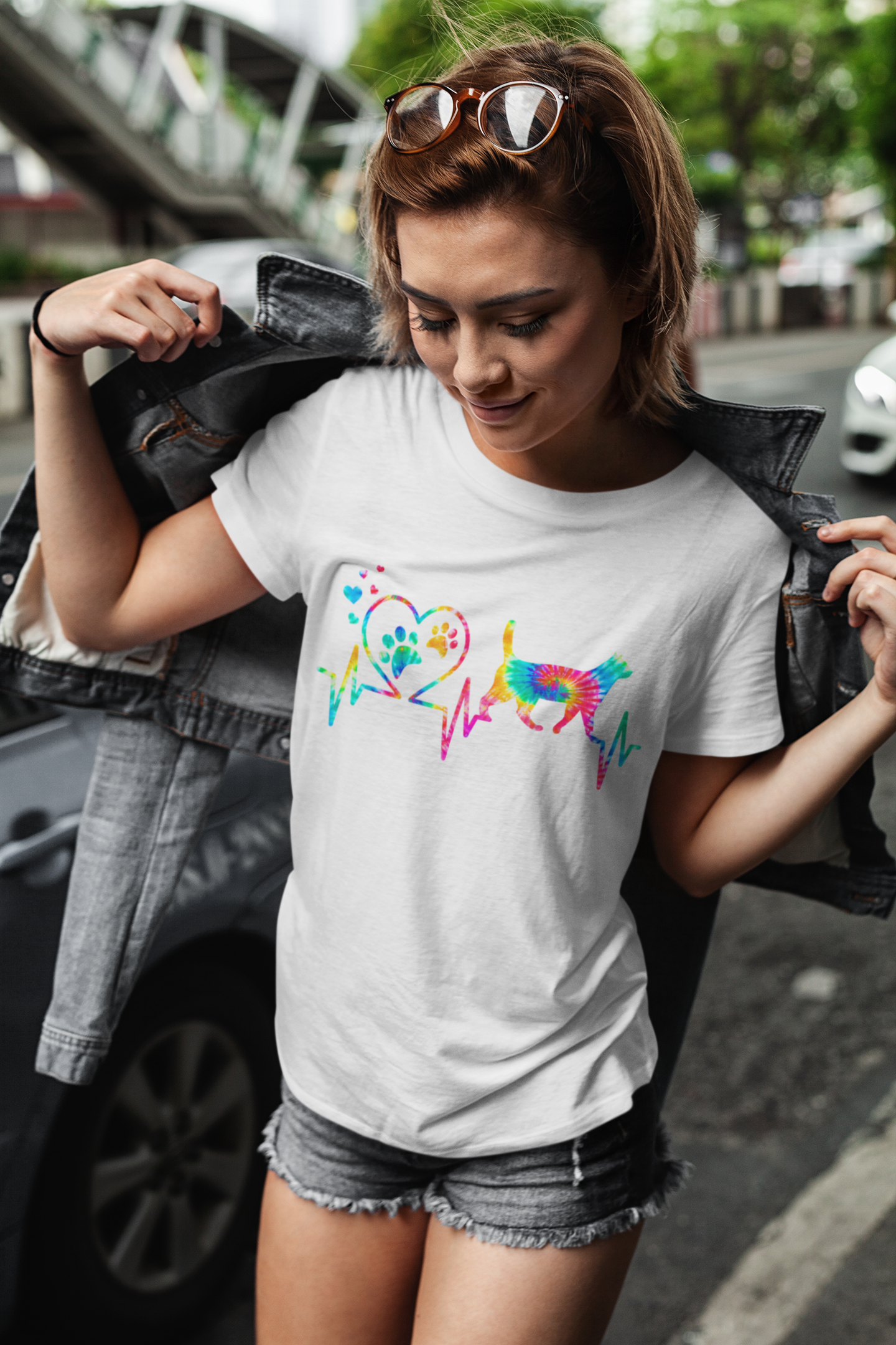 Woman wearing a white t-shirt with colorful dog design outdoors.